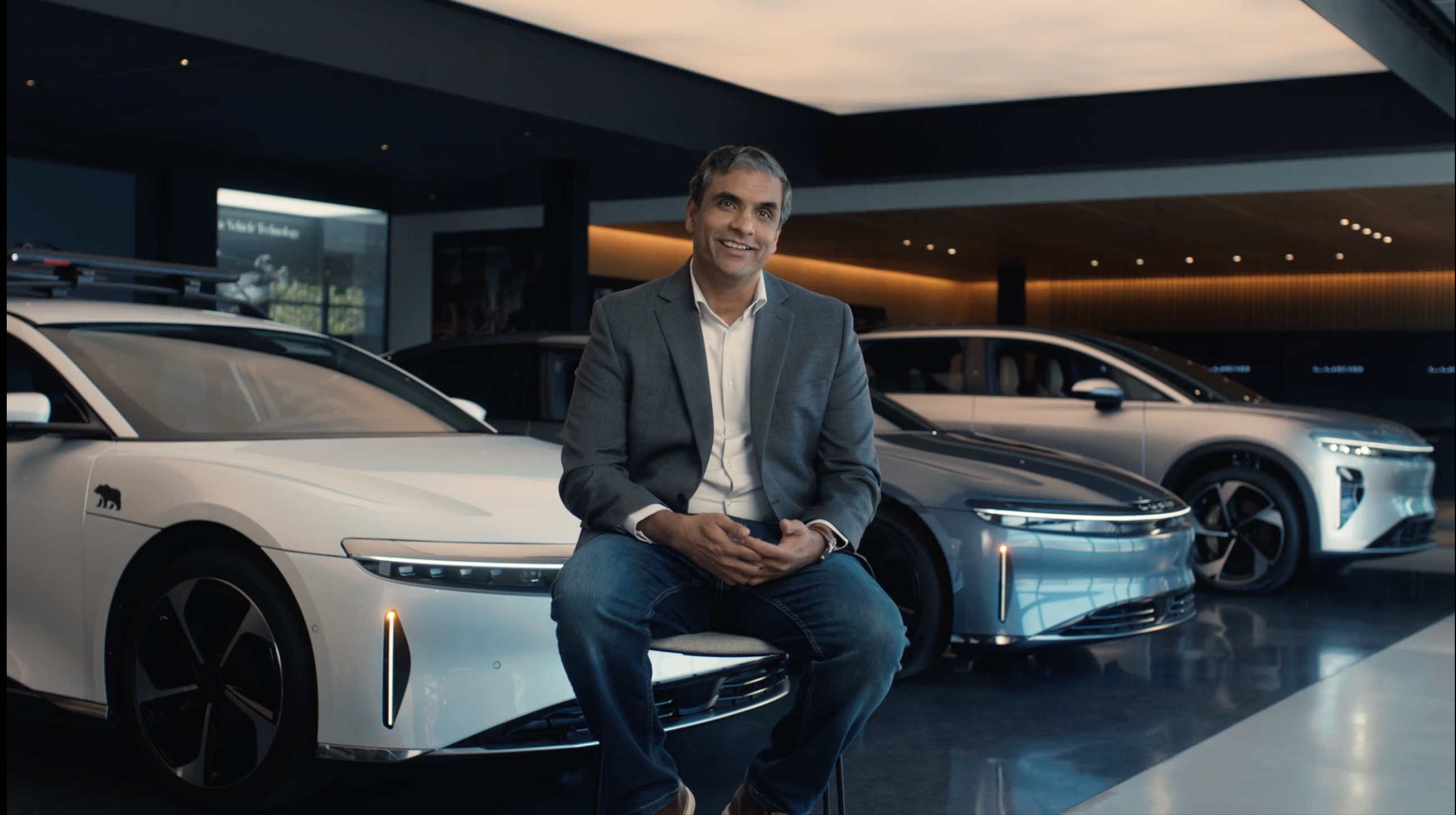 A man being interviewed among cars in a showroom